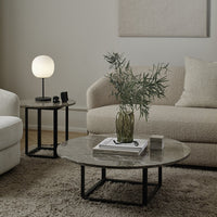 Stylish living room featuring a round marble coffee table with gray patterns, black metal legs, and neutral sofa tones.