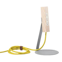 Wooden lamp with natural grain, silver metal base, and vibrant yellow cord for a modern design aesthetic.