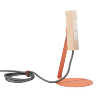 Wooden lamp with a sleek orange base and gray fabric cord, showcasing a modern, minimalist design.