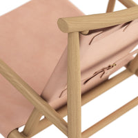Pink suede chair with natural wooden frame, featuring smooth textures and simple design. Perfect for modern decor.
