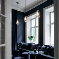 Elegant black and gold living room decor featuring pastel accents and sleek modern lighting in a dark palette.