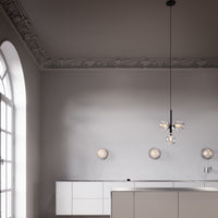 Modern kitchen with soft gray walls, white cabinetry, and decorative ceiling trim, accented by warm, circular light fixtures.