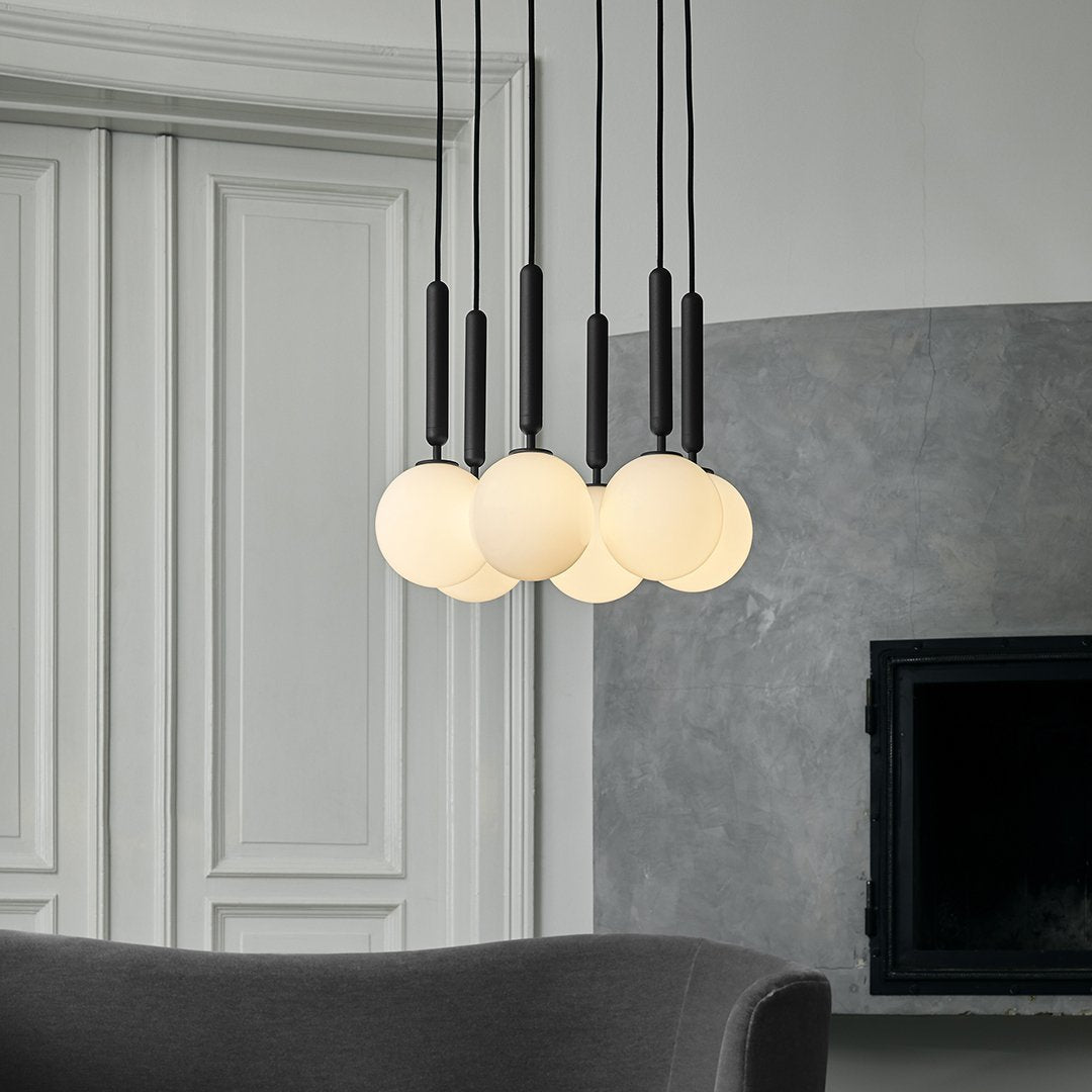 "Modern pendant light with sleek black fixtures and soft white spherical shades, enhancing contemporary decor."