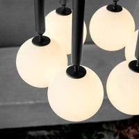Elegant white glass globes with black accents in a modern chandelier design. Perfect for contemporary decor.