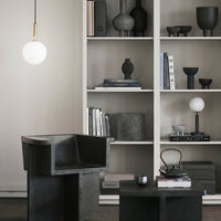 Minimalist decor featuring black pottery and light fixtures against a neutral background, creating elegant contrasts.