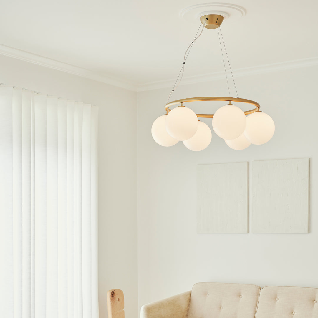 Modern chandelier with a gold frame and six white glass globes, perfect for brightening up any space.