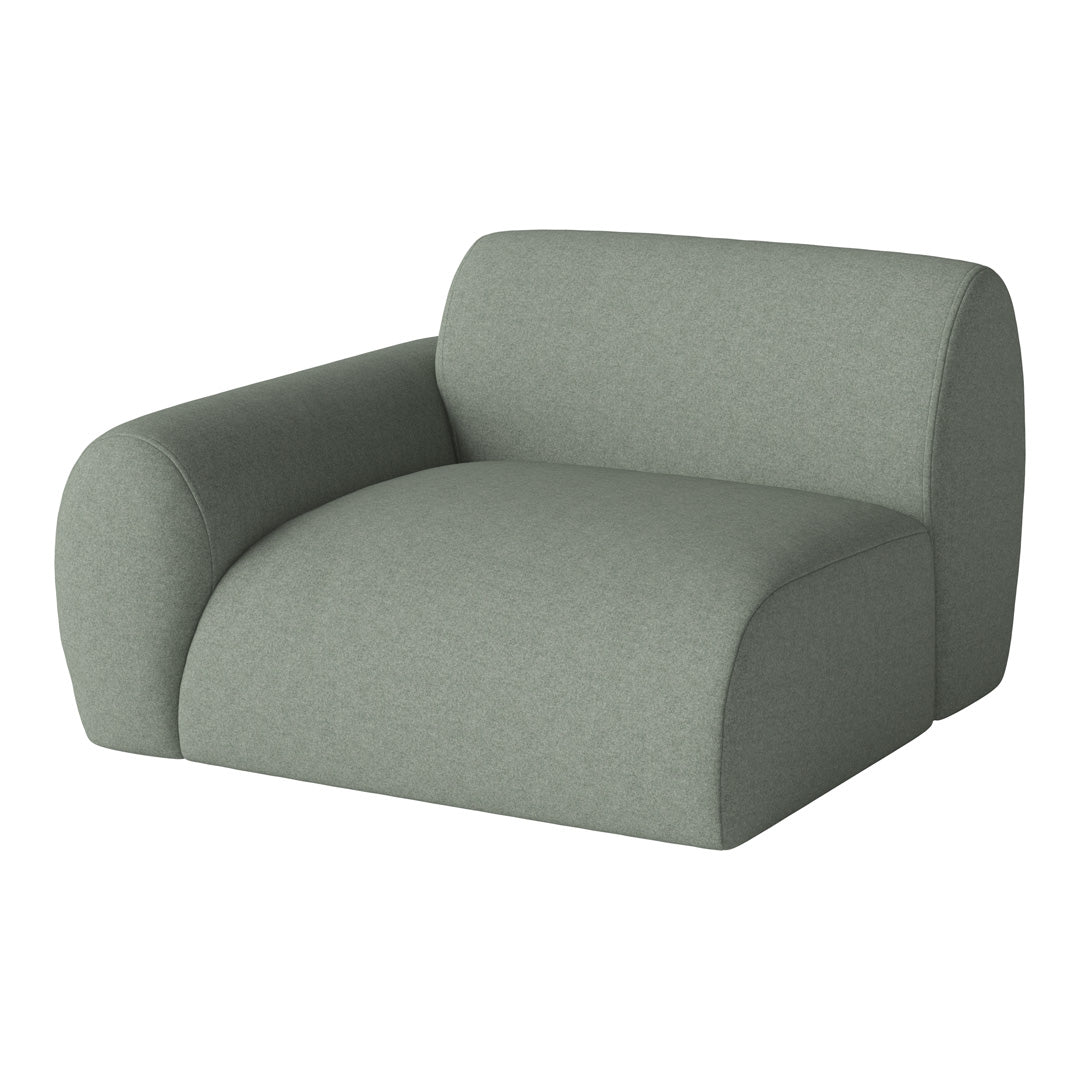 Curved armchair in soft sage green fabric with a textured, minimalistic design, perfect for modern decor.