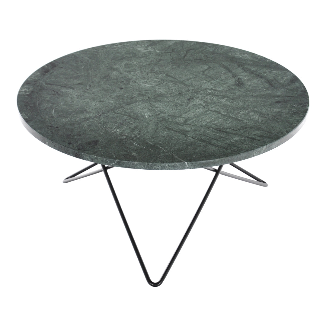 Round green marble table with a textured surface and sleek black metal legs. Stylish and modern design.