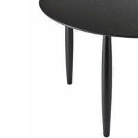 Elegant black round table with smooth surface and tapered legs, showcasing a modern, minimalist design.