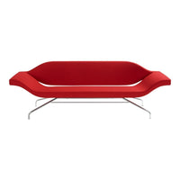 Modern red sofa with sleek design and smooth, curved contours on a chrome frame. Perfect for contemporary decor.