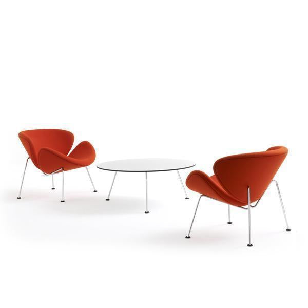 Orange upholstered chairs with sleek, modern lines, paired with a minimalist white circular coffee table.