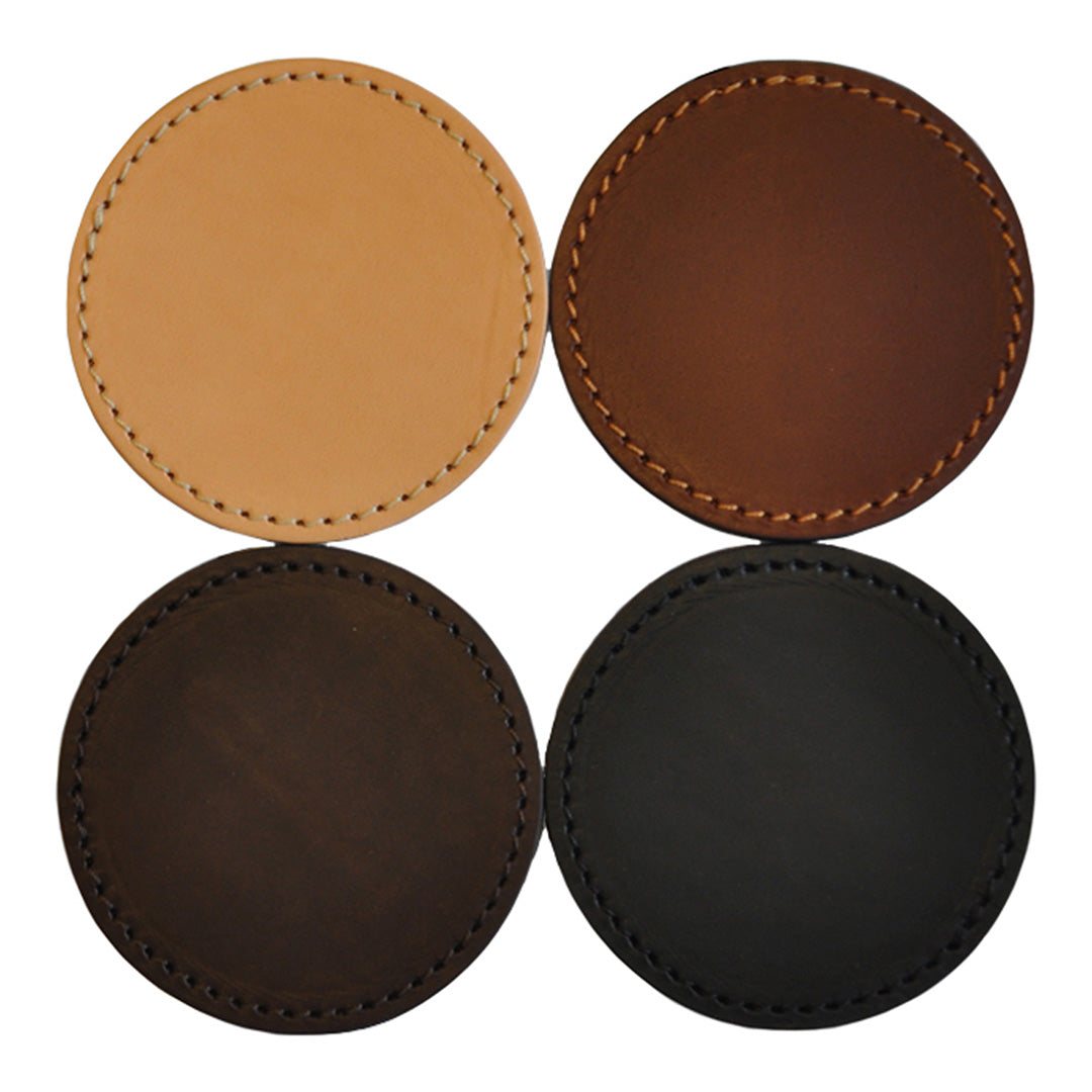 "Set of four round leather coasters in natural tan, dark brown, rich mahogany, and black with contrasting stitched edges."