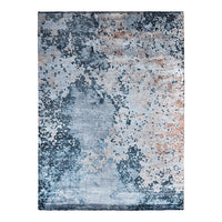 Abstract blue and gray area rug with textured patterns and hints of copper accents. Perfect for modern decor.