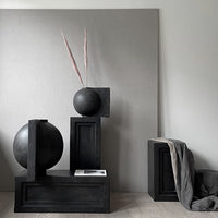Black geometric decor with soft gray backdrop and subtle pink accents, creating a modern, minimalist aesthetic.