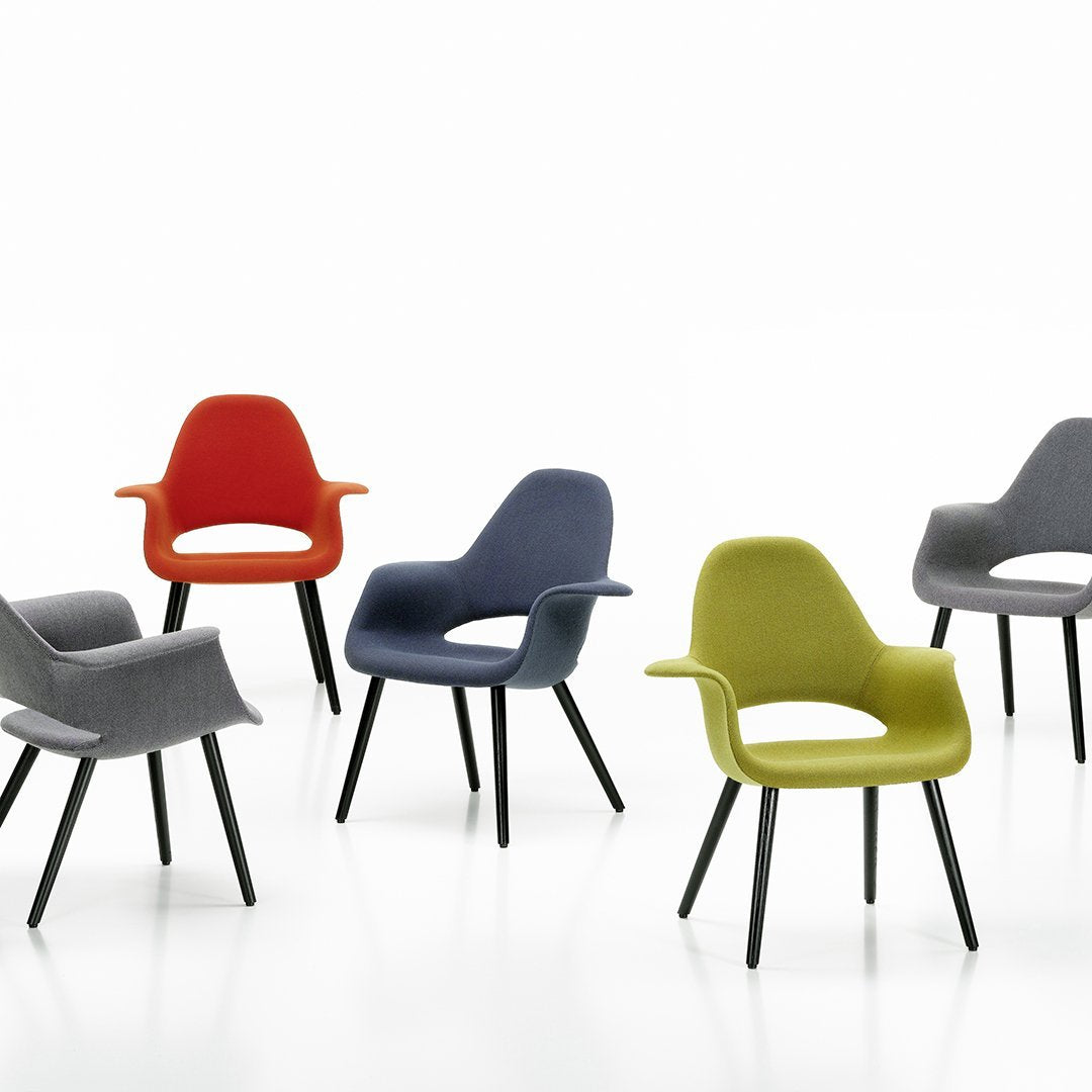 Vibrant modern chairs in red, green, gray, and blue, featuring sleek, minimalist designs and contrasting dark legs.
