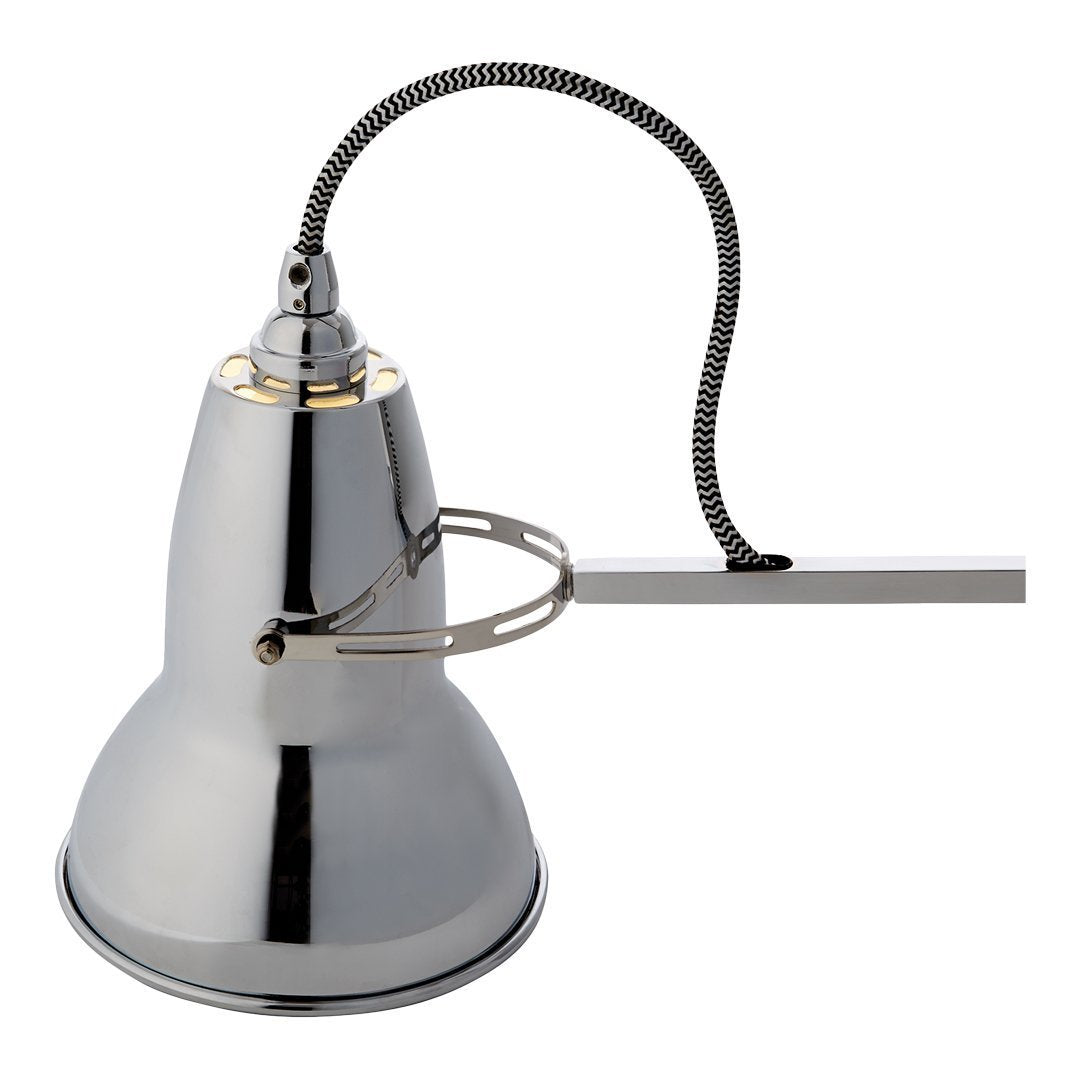 Sleek chrome lamp with a shiny finish and a black and white patterned cord. Modern design for contemporary spaces.