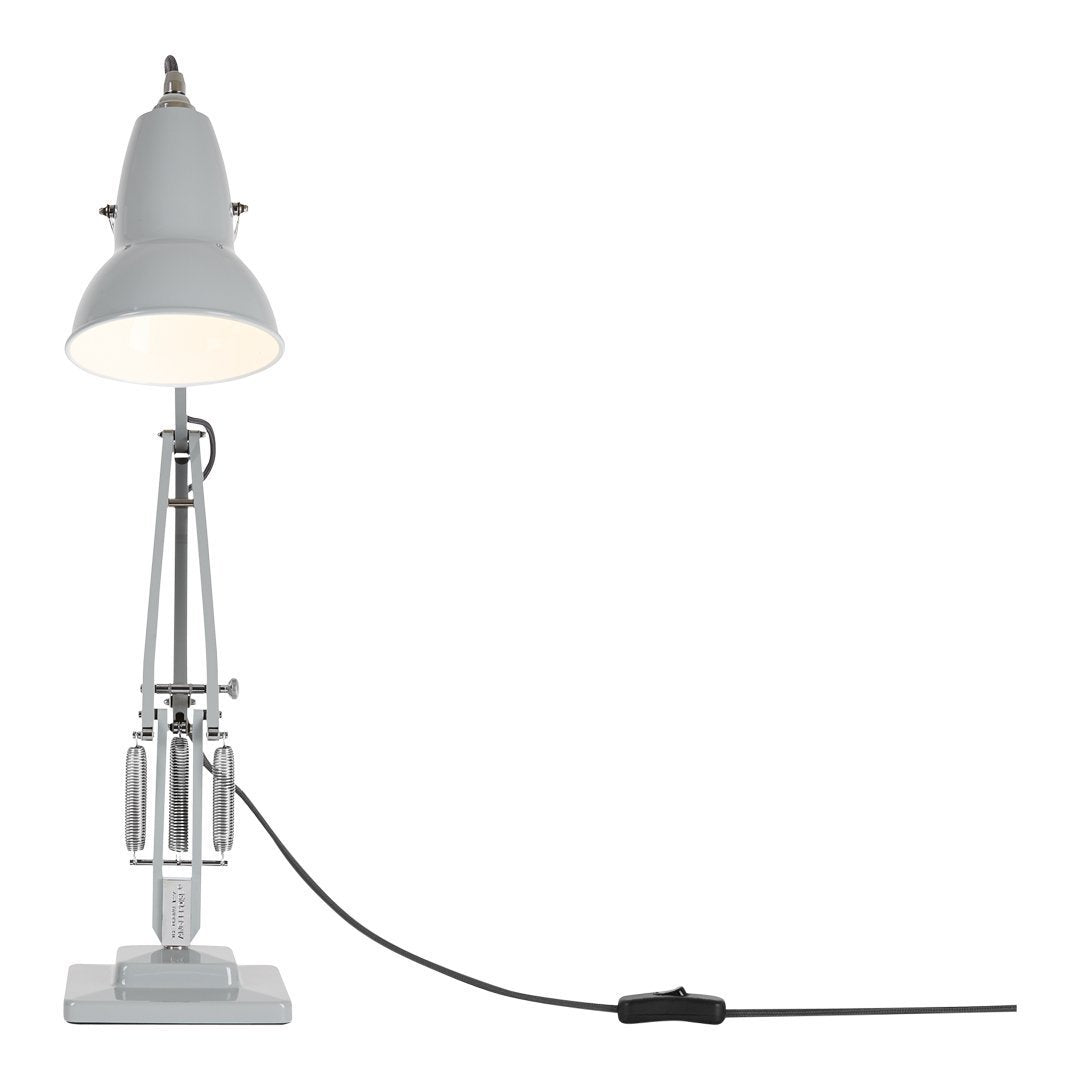White industrial lamp with a sleek metallic base and a black cord, featuring minimalistic design and modern aesthetics.