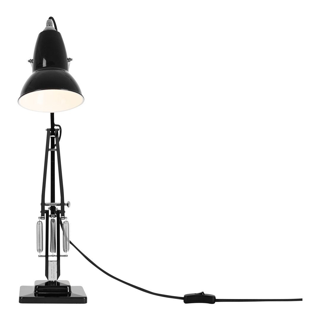 Black metal desk lamp with a sleek, modern design and a white lampshade, featuring simple geometric patterns.