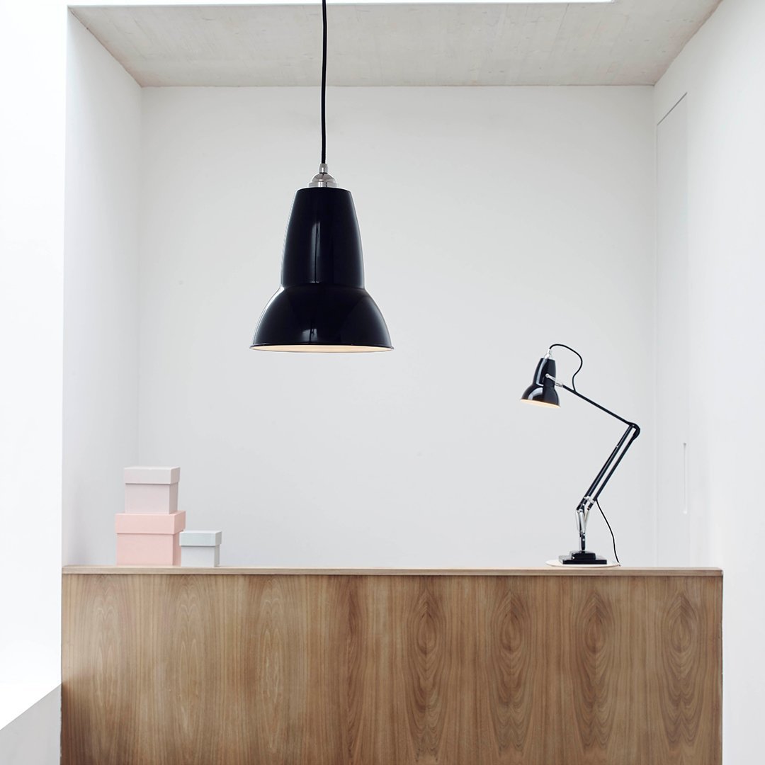 Black pendant lamp with a glossy finish, featuring clean lines and a modern design against a minimalist backdrop.