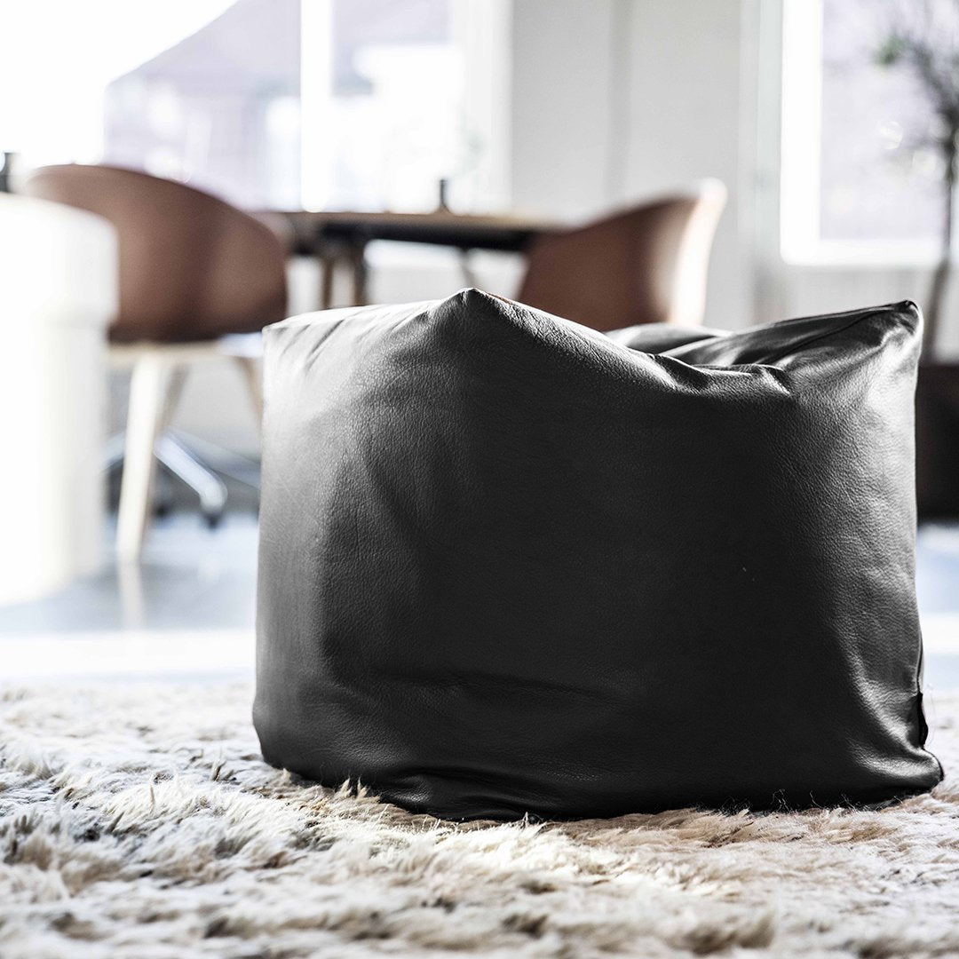 Black bean bag chair with a sleek, minimalist design, perfect for modern interiors. Soft texture, no patterns.