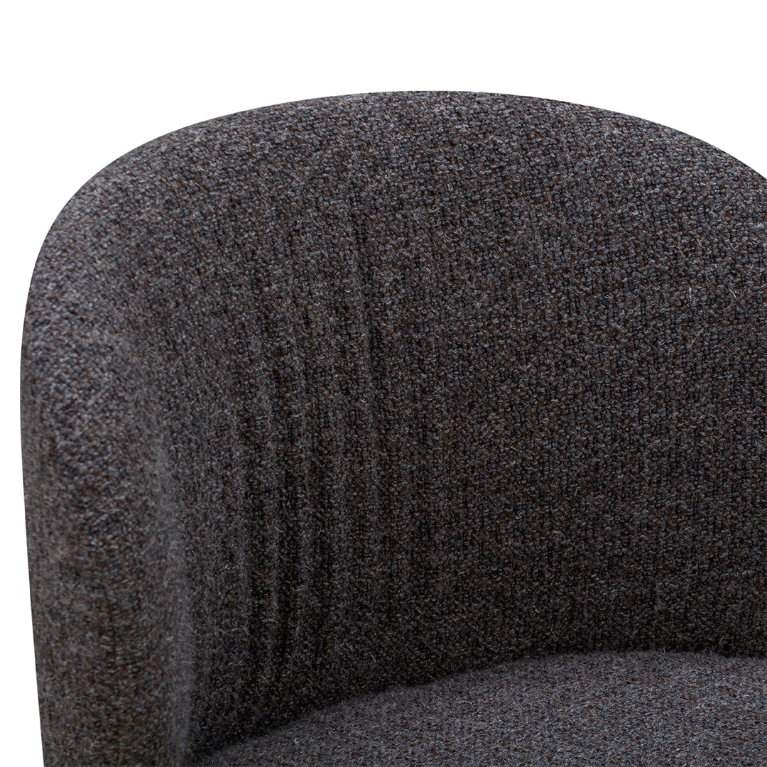Textured gray fabric with subtle black and brown flecks, featuring gentle curved lines on the chair's backrest.