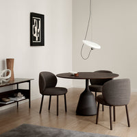 "Modern dining set with dark wood table, gray textured chairs, and neutral walls, complemented by a minimalistic lamp."