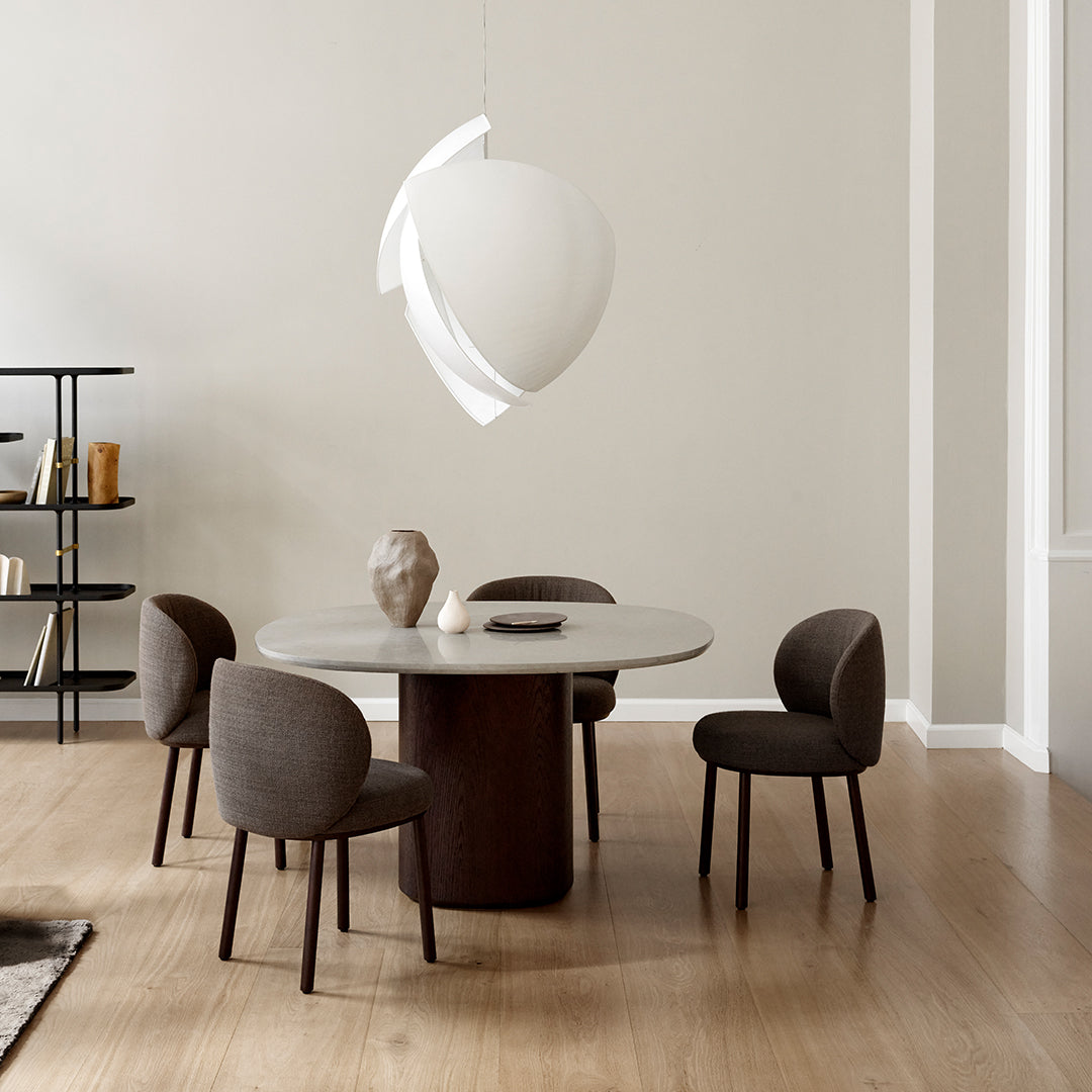 Contemporary dining table with a smooth gray top and dark wood base, complemented by brown textured chairs, minimalist design.