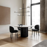 Modern dining set featuring a sleek white tabletop, black chairs, and warm wood flooring. Elegant minimalist design.