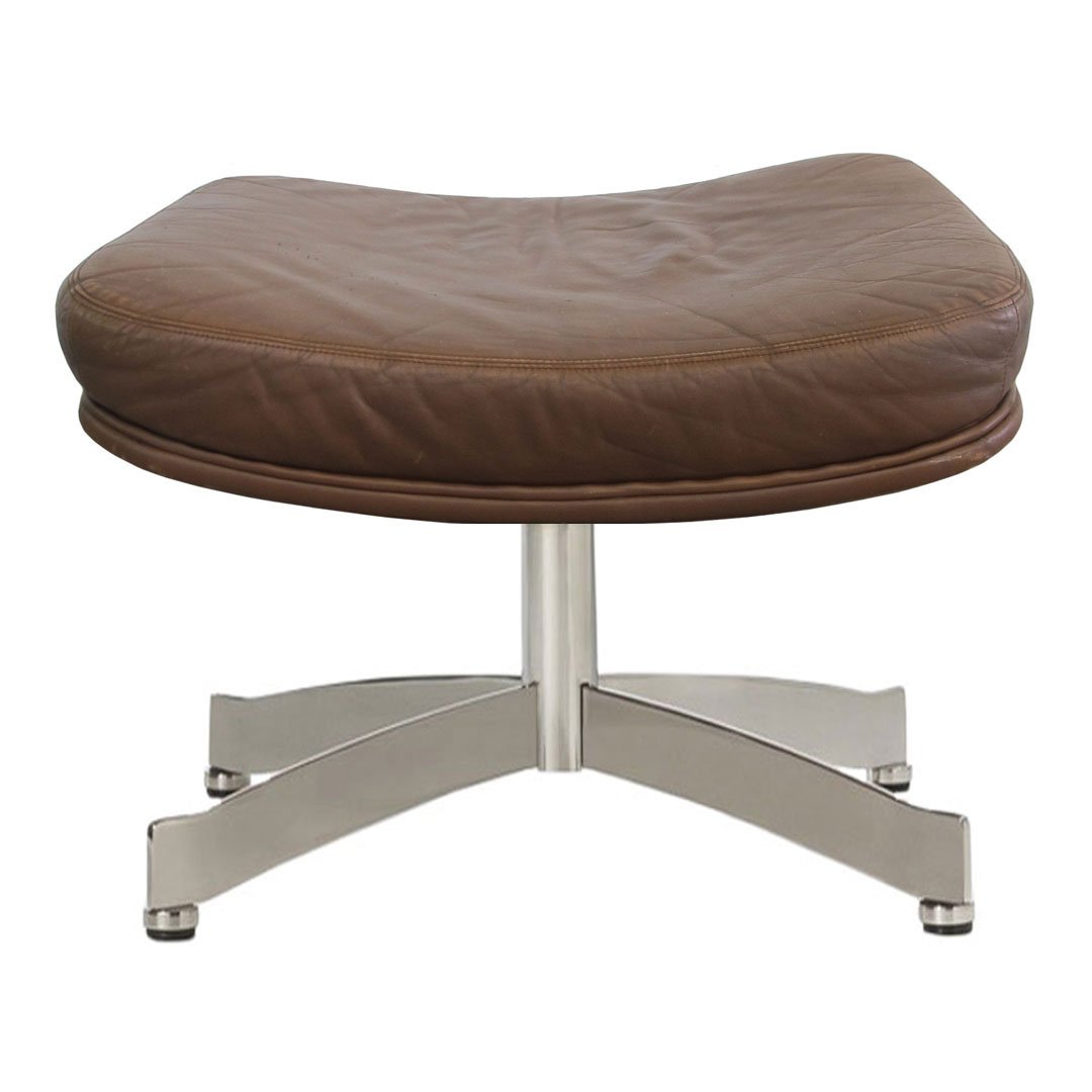 Brown leather ottoman with a smooth, curved surface and sleek silver metal base.