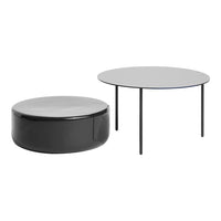 Two modern coffee tables: round glass-top in translucent gray, paired with a sleek black cylindrical table.