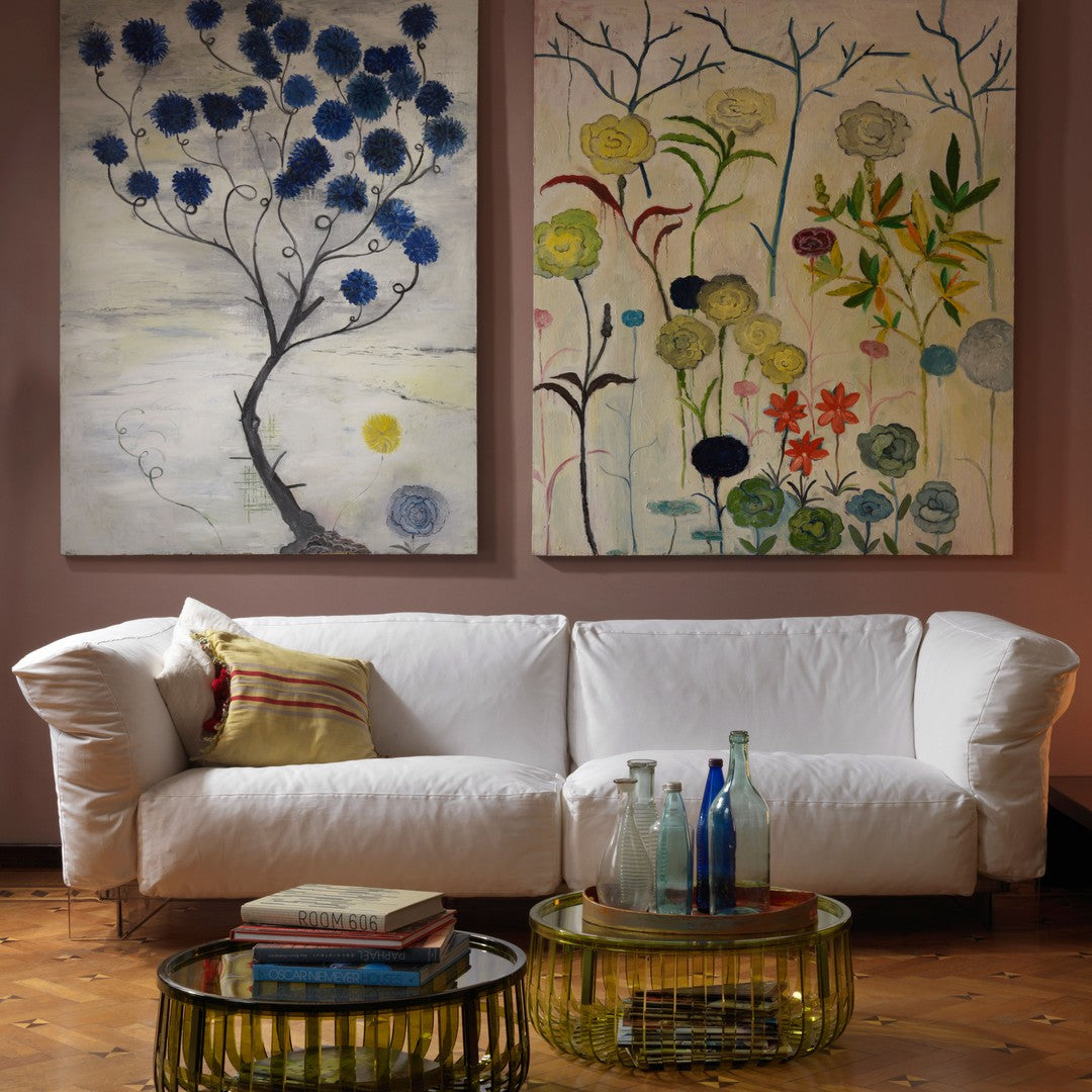 Modern sofa with vibrant blue and yellow floral paintings, featuring green, red, and earthy tones in abstract patterns.