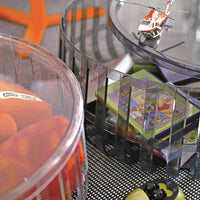 Colorful round baskets with transparent sides, featuring orange, pink, and green patterns, containing toys and books.