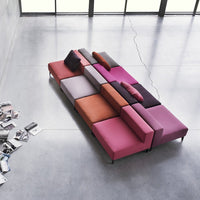 Multicolored modular sofa featuring vibrant pinks, purples, oranges, and neutral tones in a geometric pattern.