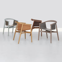 Set of four modern chairs featuring muted gray, warm brown, light tan, and soft blue tones with smooth finishes.