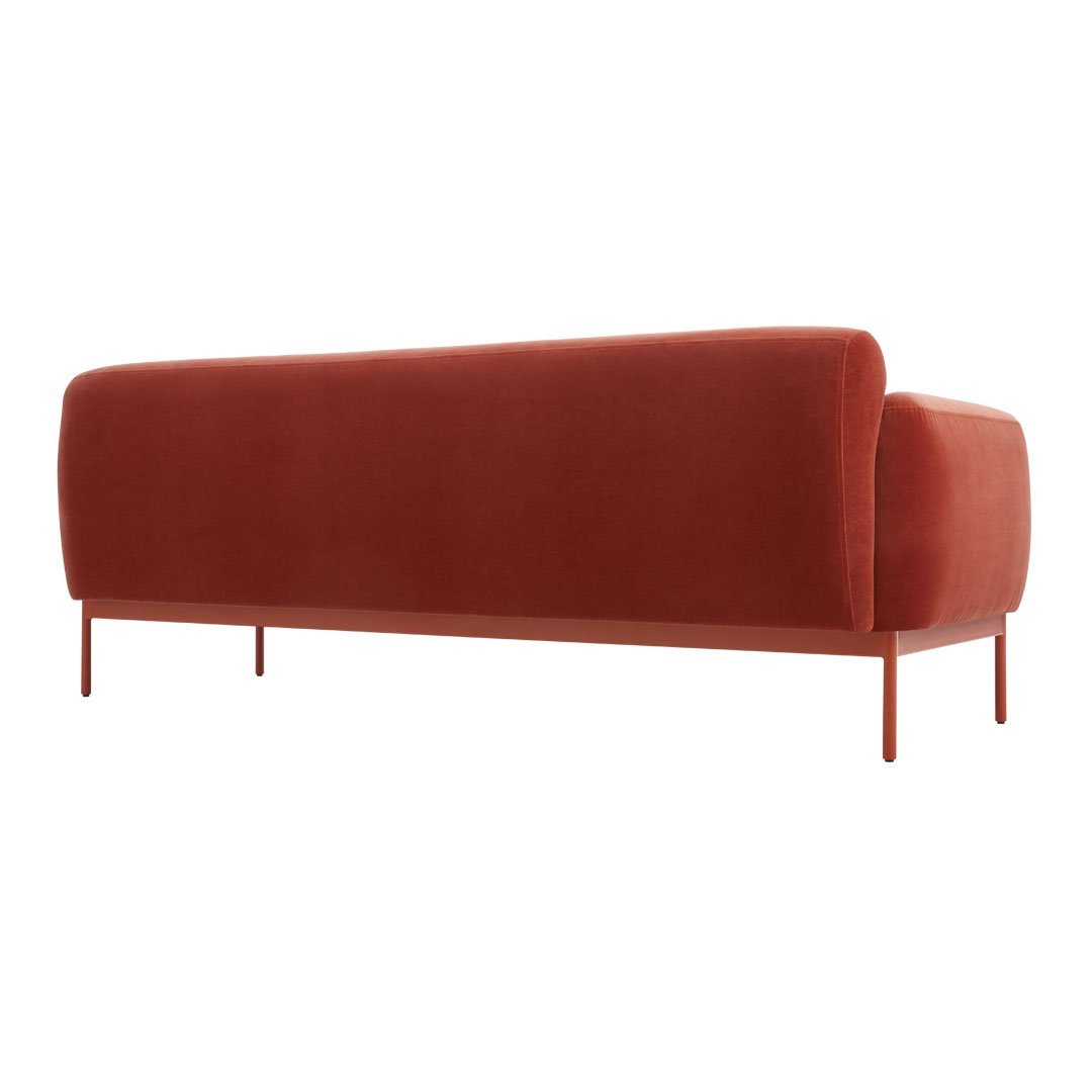 Rust-orange velvet sofa with a smooth finish and minimalist design, featuring sleek metal legs.