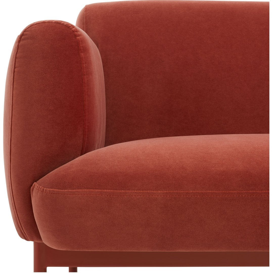 Rust-colored velvet sofa with smooth, rounded armrest and a minimalist design. Perfect for modern interiors.