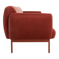 Side view of a rich burnt orange velvet armchair with smooth contours and minimalist metal legs.