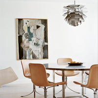 Modern dining space featuring neutral tones, beige seating, and abstract art with muted greens and grays.