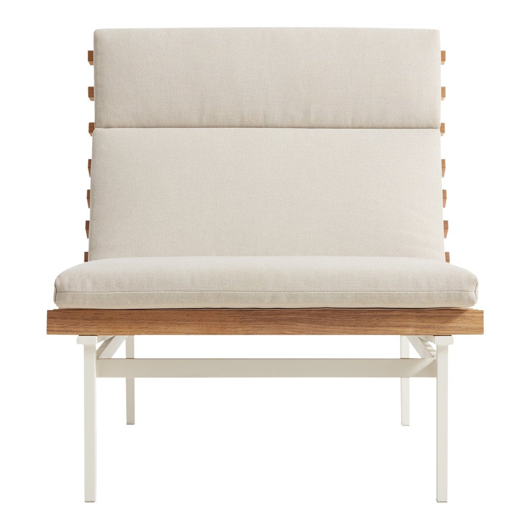 Cream upholstered chair with a smooth, minimalist design and natural wood accents, resting on a sleek white metal frame.