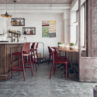 "Modern bar with red chairs and wood accents, featuring a neutral-toned floor and light-colored walls."