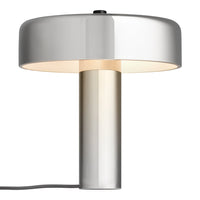 Modern silver lamp with a round shade and cylindrical base, featuring a sleek finish and soft glow.