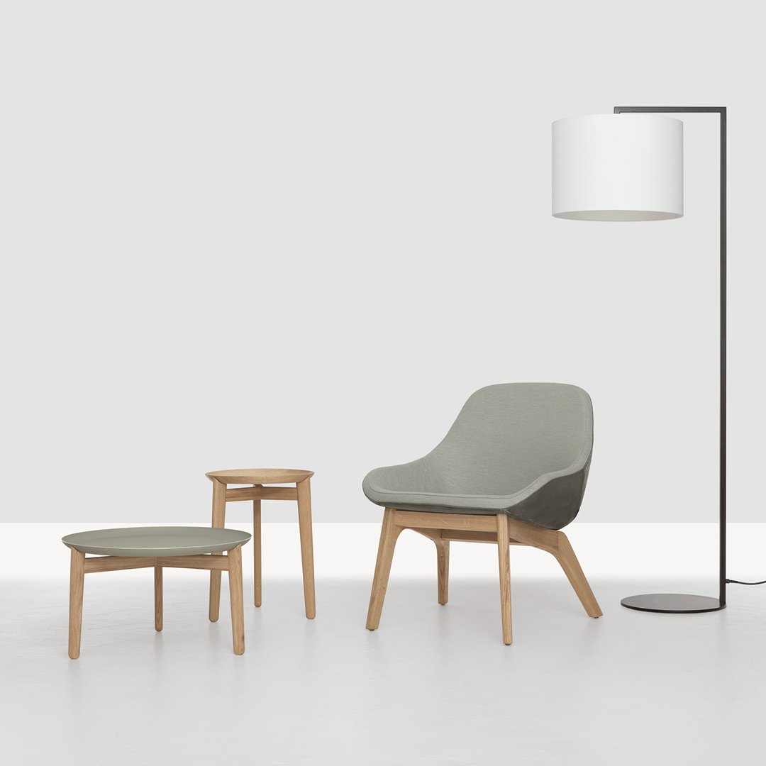 Stylish green chair with natural wood legs, accompanied by matching side table and sleek black floor lamp. Perfect modern decor.