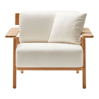 Modern white armchair with a soft cushion and natural wood accents, showcasing a minimalist design and neutral color palette.