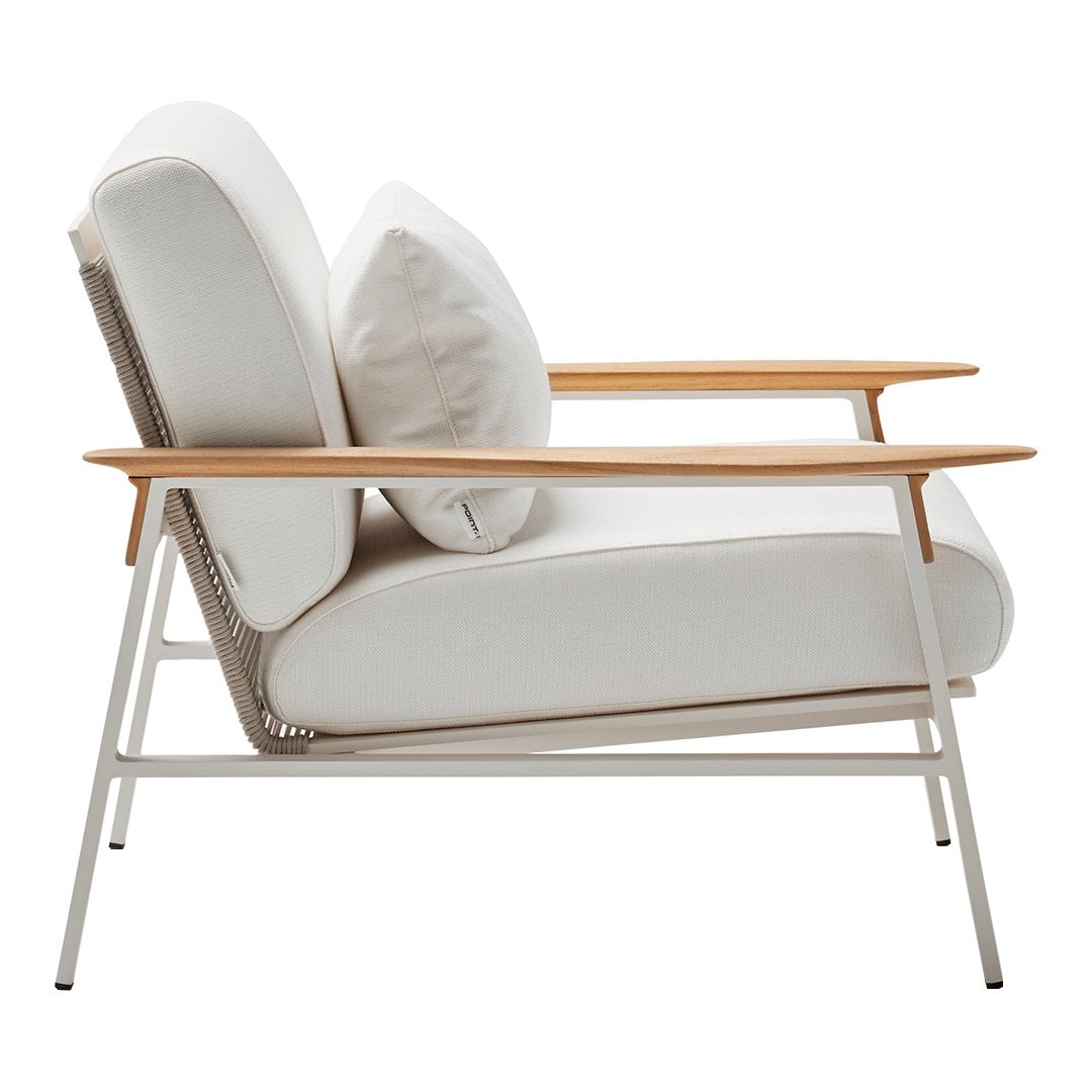 White armchair with soft cushions and natural wood accents, featuring a minimalist design and elegant lines.
