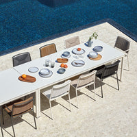 "Outdoor dining set featuring neutral tones, round and rectangular plates, and woven texture chairs."
