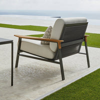 Stylish gray and beige outdoor chair with wooden armrests and subtle textured patterns on cushions and frame.
