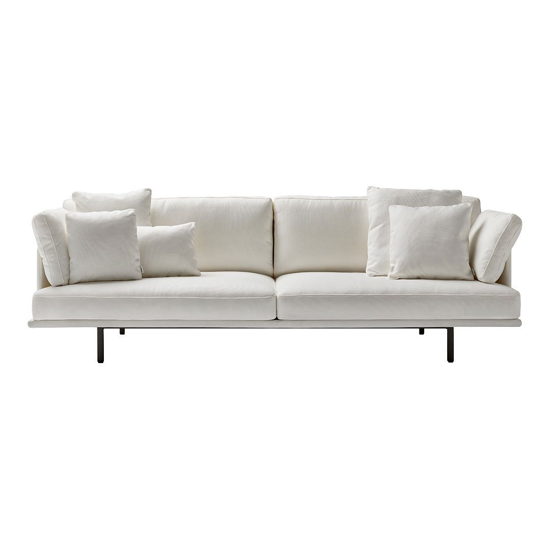 Elegant white sofa with soft texture and matching plush cushions, featuring a minimalist design and sleek black legs.