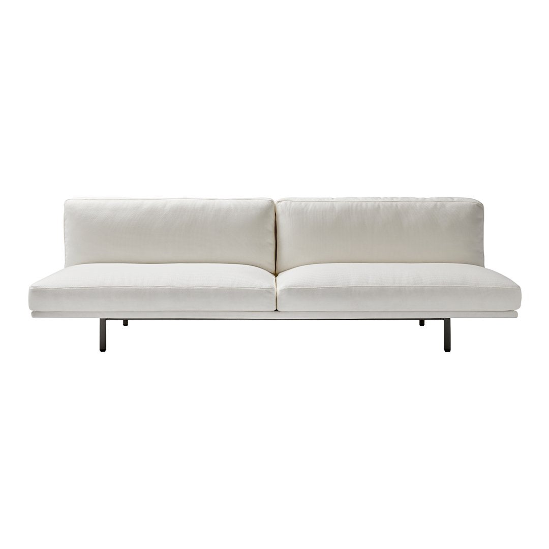 Modern white sofa with sleek cushions and a minimalist design, featuring a solid black metal base.