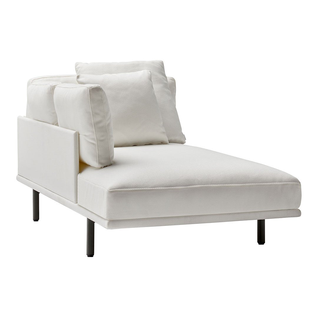 Chic white chaise lounge with soft cushions and sleek black legs, perfect for modern minimalist decor.