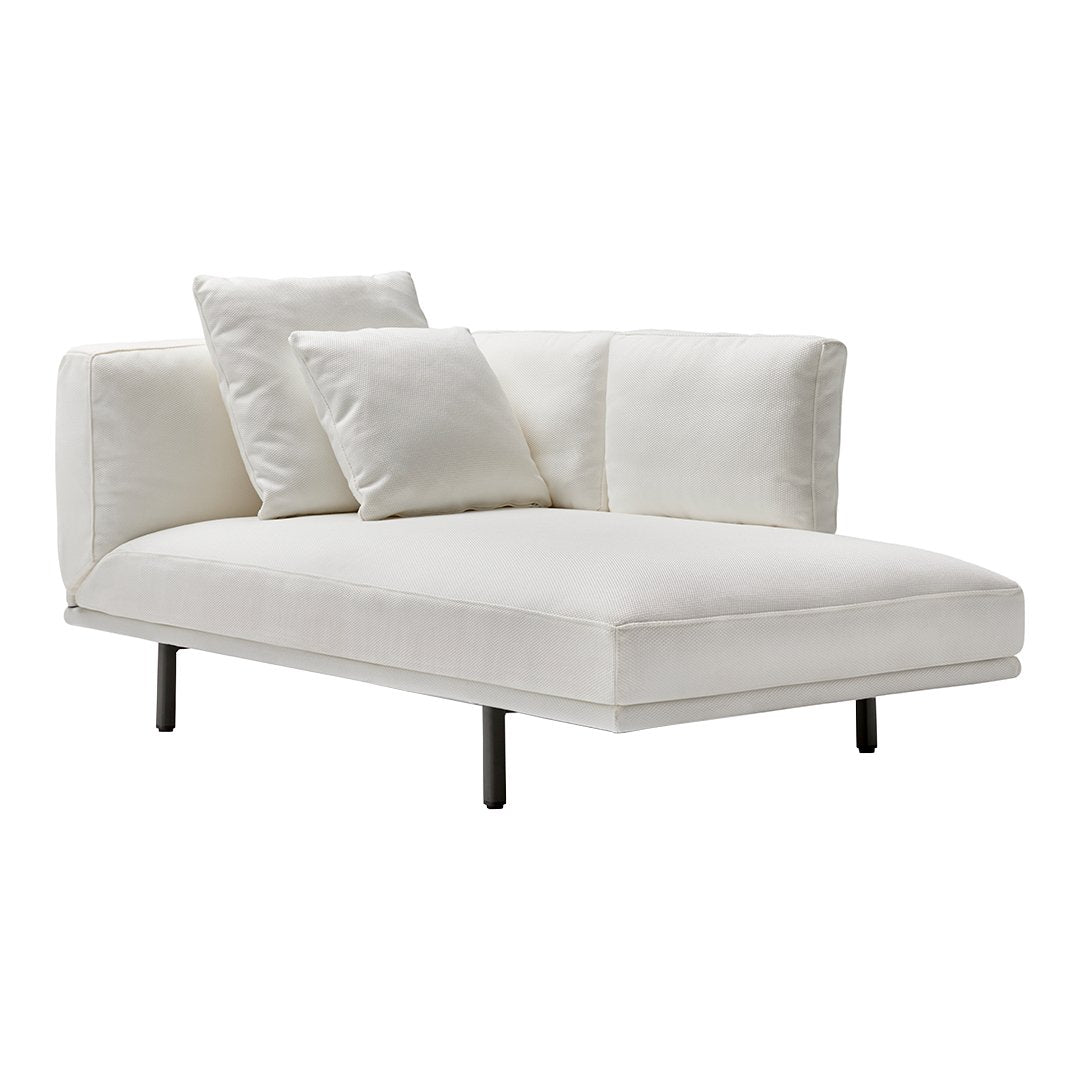 Elegant white chaise lounge with smooth fabric and simple, modern lines, complemented by three plush pillows.